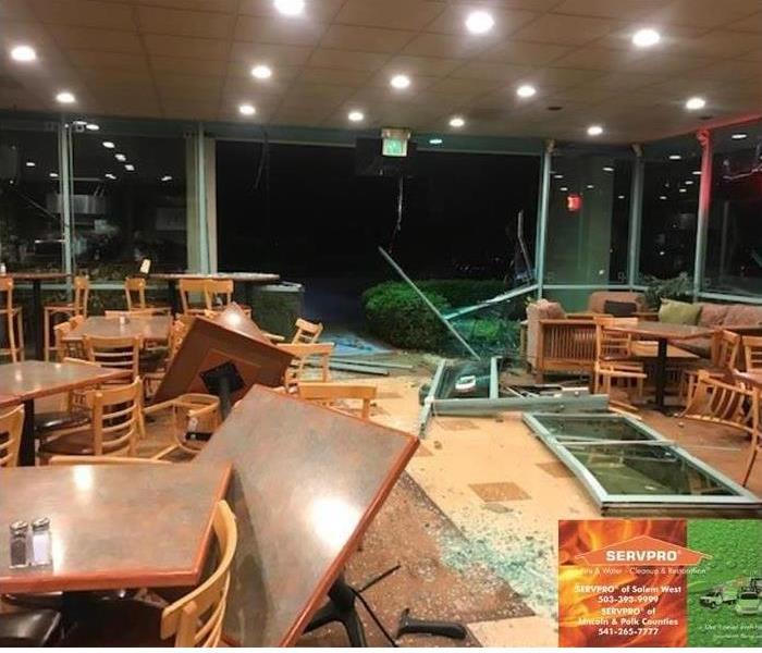 a restaurant dining room with a broken out window and debris everywhere