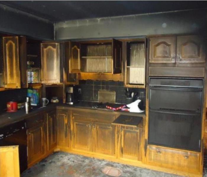 a kitchen after a stove fire -blackened soot on walls and surfaces